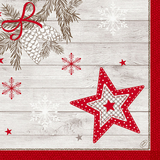 Ein rustikaler Holzhintergrund mit weißen Tannenzapfen, rotem Band, Schneeflocken und einem roten Gingham-Stern, eingefasst von rotem Strukturstoff mit abgesteppter Kante - ideal zum Hervorheben der Dunilin-Servietten 40x40cm von Duni GmbH.