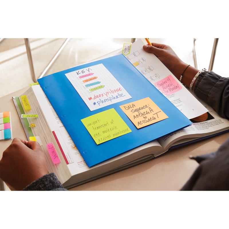 A person studying with an open textbook and a blue folder with 3M Post-it® Notes from the Energetic Collection (PEFC certified), with handwritten reminders, a labeled DNA diagram, and colorful page tabs, 76 x 127 mm, 6 blocks/pack.