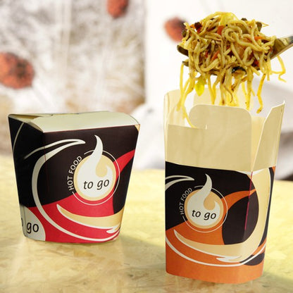 Two Starpak 50 snack boxes "To Go" square – 550 ml stand on a light surface; one is closed, the other open, and noodles are being lifted out with a fork. The blurred background emphasizes the practical design for takeout.