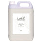 The 5-liter canister of the LAPE Earth Collection Sakura Sea Breeze Hand & Body Lotion by Diversey Germany has a floral-fresh scent, a handle, a screw cap, and a white label with black text and abstract line motifs.