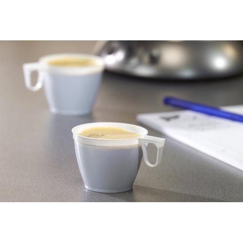 Two small Starpak coffee cups (PS, 0.18l, Ø7.8cm, white) from a set of 10 are filled with coffee on a gray surface, with a blue pen and a blurred white sheet of paper visible in the background.