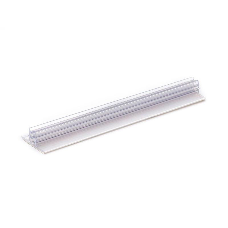The Orkla Wound Care AB Clip sign | Pack (1 piece) is a transparent shelf label holder made of plastic with a flat base and a vertical slot for labels, which is perfect for organizing or labeling items. Pictured against a white background.