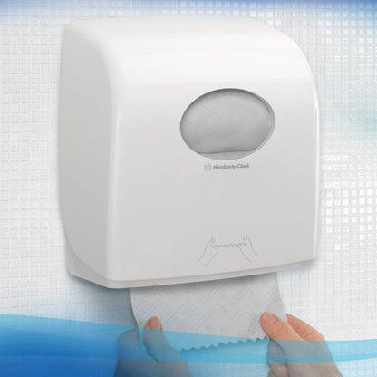 A person pulls Scott® Essential™ Slimroll™ Hand Towels (190 m x 19.8 cm) from a white dispenser by Kimberly-Clark GmbH on a tiled wall; an illustration shows environmentally friendly hand drying with these paper towels.