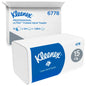 Eine Kleenex® Falthandtücher Weiß/Groß-Packung der Kimberly-Clark GmbH steht vor einem Marken-Versandkarton, beide mit 15 Clips x 124 Blatt pro Karton (15 Packungen), insgesamt 1.860 Tücher.