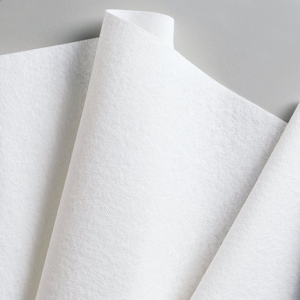 Close-up of overlapping Kimberly-Clark GmbH WypAll® L40 PowerClean quarter-folded paper towels (white, 18 packs x 56 sheets), arranged at an angle against a neutral background.