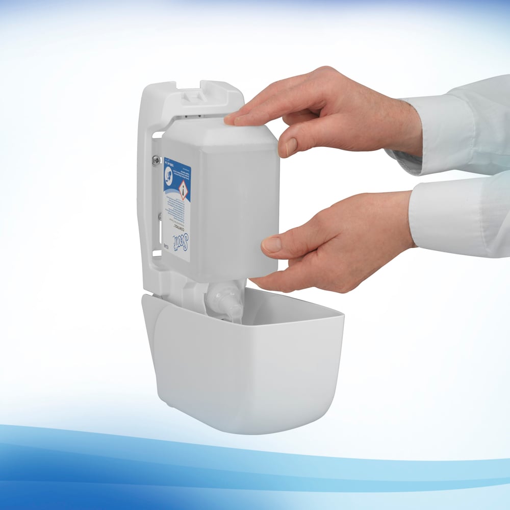 A person refills a wall-mounted dispenser with a rectangular Scott® Anti Bac Foam Soap 1L cassette from Kimberly-Clark GmbH. The white, front-opening dispenser helps maintain optimal hygiene washroom standards.