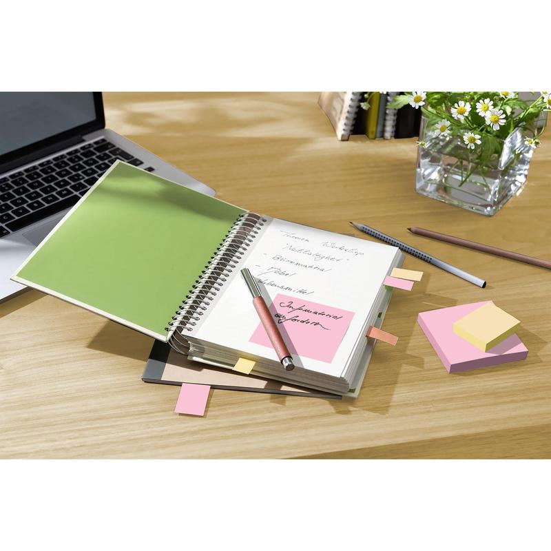 A notebook with handwritten notes and 3M Post-it® Recycling Notes (38 mm x 51 mm, 100% PEFC) lies open on a wooden table next to a laptop, pens, and a vase with white daisies.
