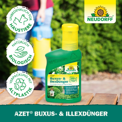 Eine grüne Flasche von Neudorff Shop Azet Buxus- & IlexDünger flüssig steht auf einer Holzfläche im Freien. Icons zeigen die Sicherheit für Haustiere, biologische Inhaltsstoffe und recycelte Verpackungen. Das Neudorff-Logo erscheint in der oberen rechten Ecke.