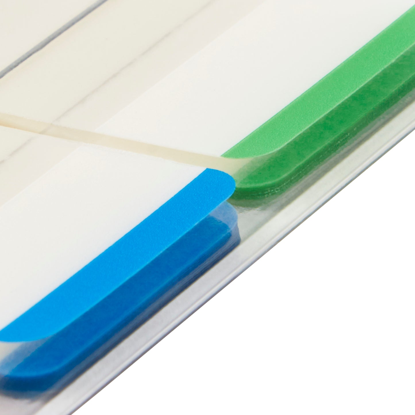 Close-up of a file folder with two Post-it® Index Strong Filing Tabs from 3M Deutschland GmbH - one blue and one green, each 25.4 x 38.1 mm - separated by a transparent film. The raised tabs are visible at an angle.