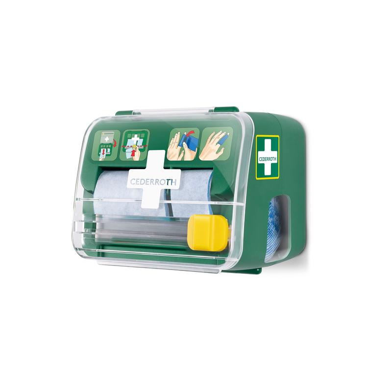 A green, transparent Cederroth soft foam bandage 2-in-1 dispenser from Orkla Wound Care AB is mounted on a white wall, holds packaged material, and displays an illustrated first aid guide on the front.