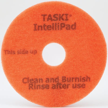 Ein orangefarbenes rundes TASKI Intellipad Kombiniertes Reinigungs- und Polierpad für Unterhaltsreinigung von Diversey Deutschland GmbH & Co. OHG, mit zentralem Loch und Text: "TASKI Intellipad", "Diese Seite nach oben", "Reinigen und Polieren Nach Gebrauch ausspülen.