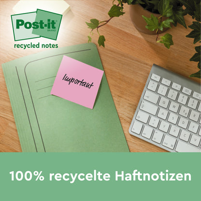 Ein pinkfarbener Post-it® Recycling-Zettel (76x76mm, 100 Blatt, 100% PEFC) der 3M Deutschland GmbH mit der Aufschrift "Wichtig" ist an einem grünen Ordner auf einem Holzschreibtisch neben einer weißen Tastatur und einer grünen Pflanze befestigt. Text: "100% recycelte Haftnotizen".