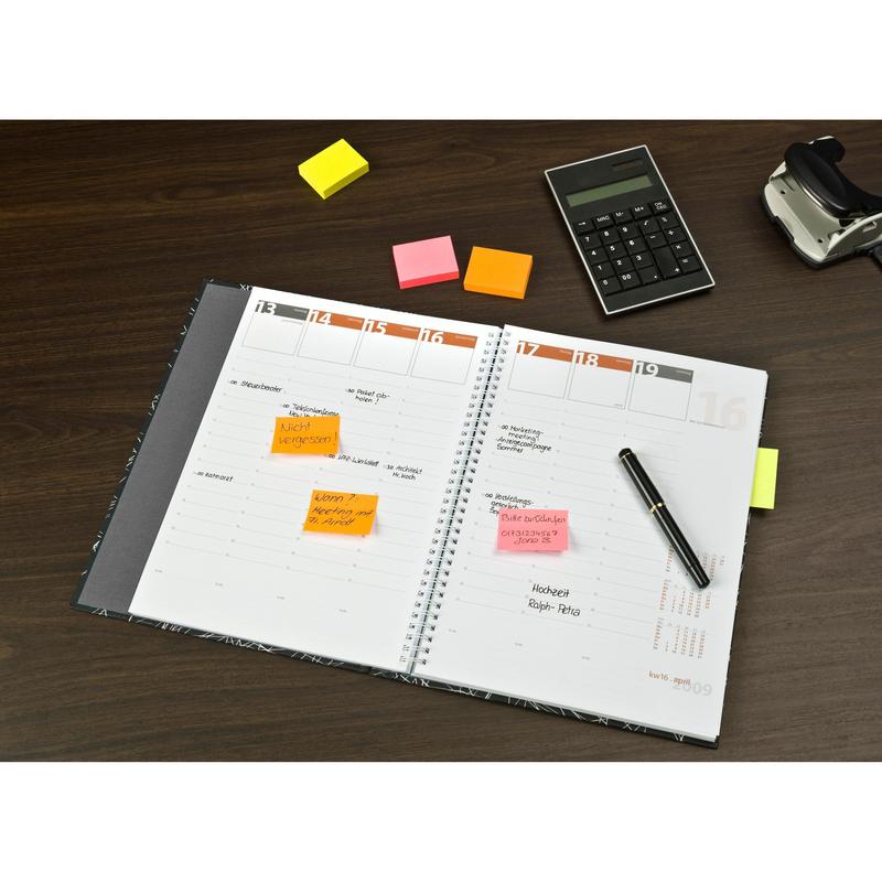 An open planner with handwritten notes and colorful Post-it® Notes Various Neon Colors (38 mm x 51 mm, 100 sheets/pad, 3 pads/pack, 100% PEFC) from 3M Deutschland GmbH on a wooden table with pen, calculator, and tape dispenser.