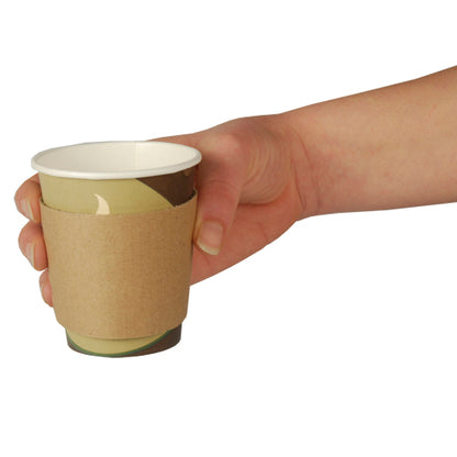 A hand holds a PAPSTAR sleeve for hot beverage cups "pure", brown, Ø 7.3 cm paper cup with dispenser box (100 pieces) from PAPSTAR GmbH in front of a plain white background.
