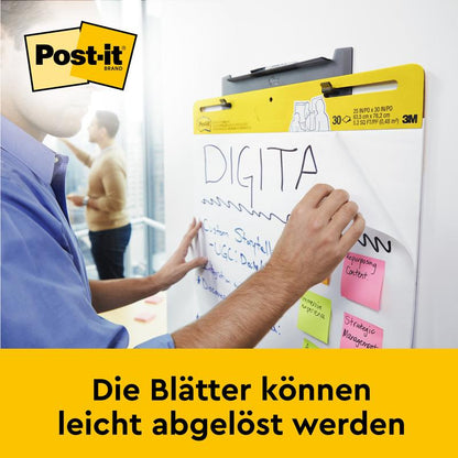 Someone writes on the Post-it® Super Sticky self-adhesive Meeting Chart/Flipchart for wall mounting 559 (63.5 x 76.2 cm) from 3M Deutschland GmbH. Several sticky notes are attached to it. The sheets can be easily removed.