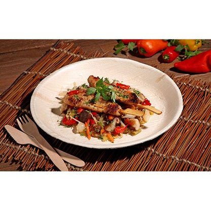 Grilled meat skewer with mixed vegetables and herbs is served on a PAPSTAR 25 plate, palm leaf "pure" round from PAPSTAR GmbH, with environmentally friendly disposable tableware and colorful bell peppers and vegetables in the background.
