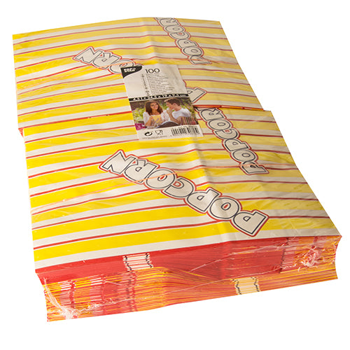 Pictured is a stack of PAPSTAR 100 popcorn bags, yellow-red striped greaseproof parchment substitute bags with the slanted print "POPCORN", with a visible packaging label of PAPSTAR GmbH on top.