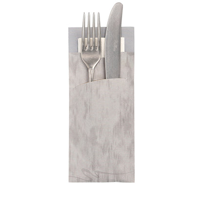 A silver fork and knife rest in a PAPSTAR 520 cutlery bag (20x8.5cm, 2-ply) with an integrated matching napkin from PAPSTAR GmbH, handles protrude and the napkin is partially visible behind.