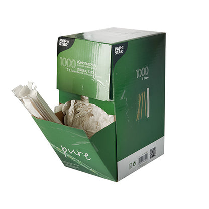 A green-white box from PAPSTAR GmbH with the inscription "1000 wooden stir sticks, "pure", individually wrapped" shows several wooden stir sticks protruding from the open front side.