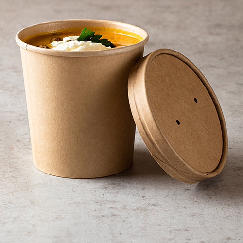 On a light countertop stands a brown Starpak soup cup filled with soup, cream, and parsley; next to it rests the Starpak 25 lid for soup cups, cardboard round.