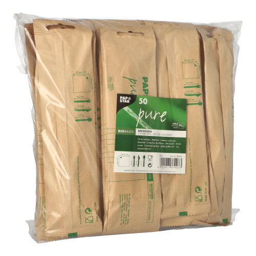 A clear packaging from PAPSTAR GmbH contains 50 "pure" wooden cutlery sets with napkins, each individually wrapped in biodegradable brown paper and labeled with the green "pure" inscription.