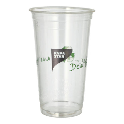 A clear PLA cup "Cup made of corn" from PAPSTAR GmbH with green text stands upright and empty against a white background. This eco-friendly drinking cup is biodegradable.