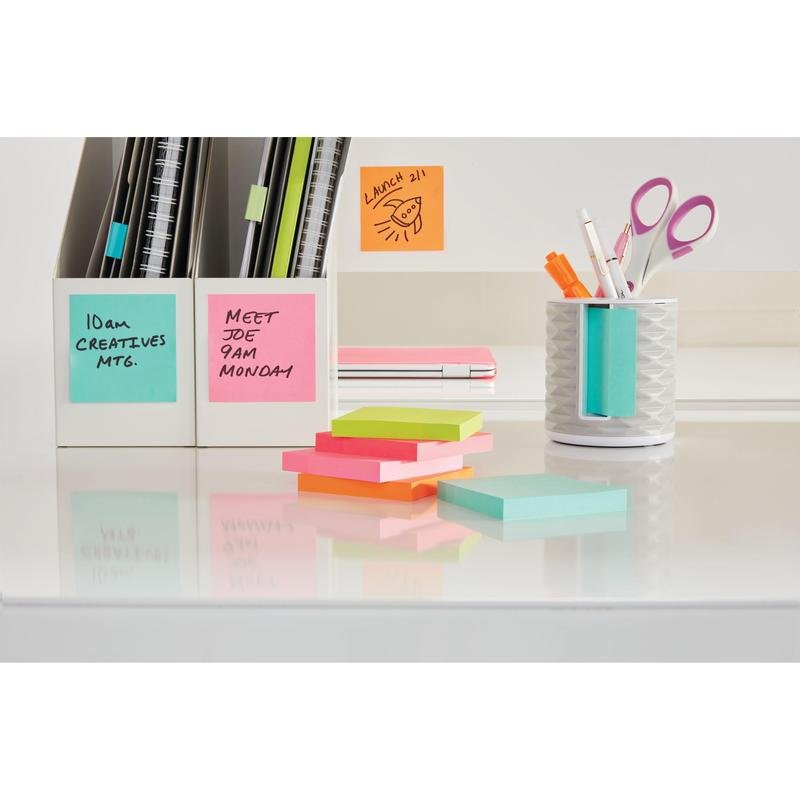A tidy desk with colorful 3M Post-it® Notes from the Energetic Collection (76x127 mm, 100% PEFC, SGSCH-PEFC-COC-110078) in two white holders, with scissors, pens, and stacks reminding of meetings and lunches.