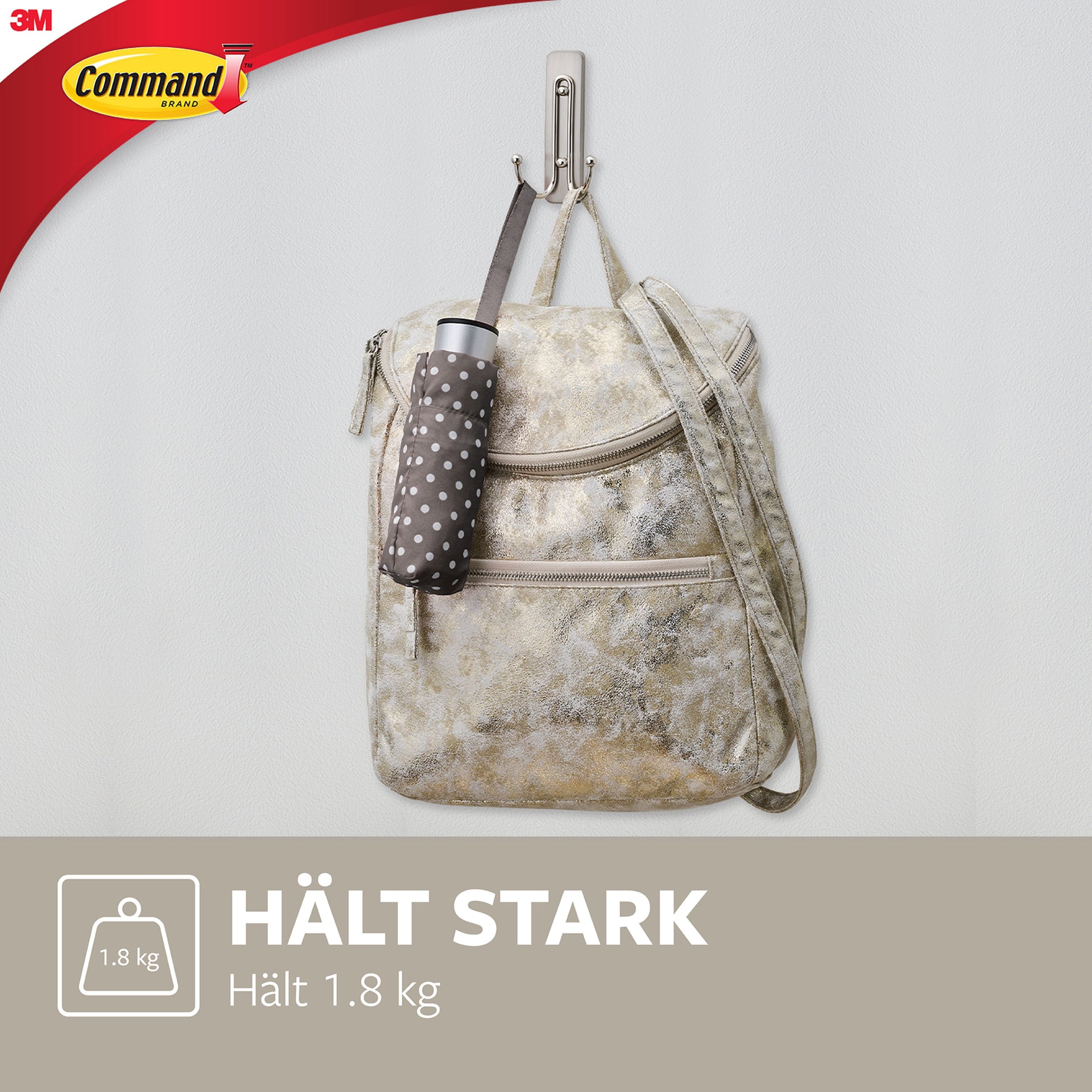 Ein beige-grauer Rucksack und ein gefalteter Regenschirm mit Punkten hängen an einem großen Command™ Doppelhaken aus gebürstetem Nickel (17036) von 3M Deutschland GmbH, der bis zu 1,8 kg trägt. In der linken oberen Ecke ist das Command-Logo zu sehen.