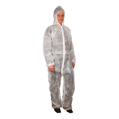 A person wears the disposable overall from Abena Re-Seller GmbH, a white, loose-fitting, light-permeable protective overall made of PP nonwoven with a hood. The person stands in front of a plain white background.