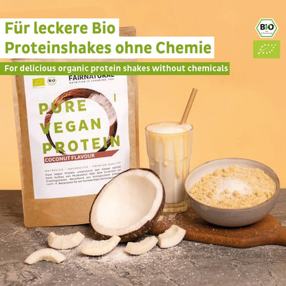 A package of Fairnatural® Organic Vegan Protein Powder Coconut without Soy, a glass of vegan protein shake, a measuring scoop of powder, and coconut pieces are arranged on a light surface. The label highlights organic protein, perfect for muscle building or diet.