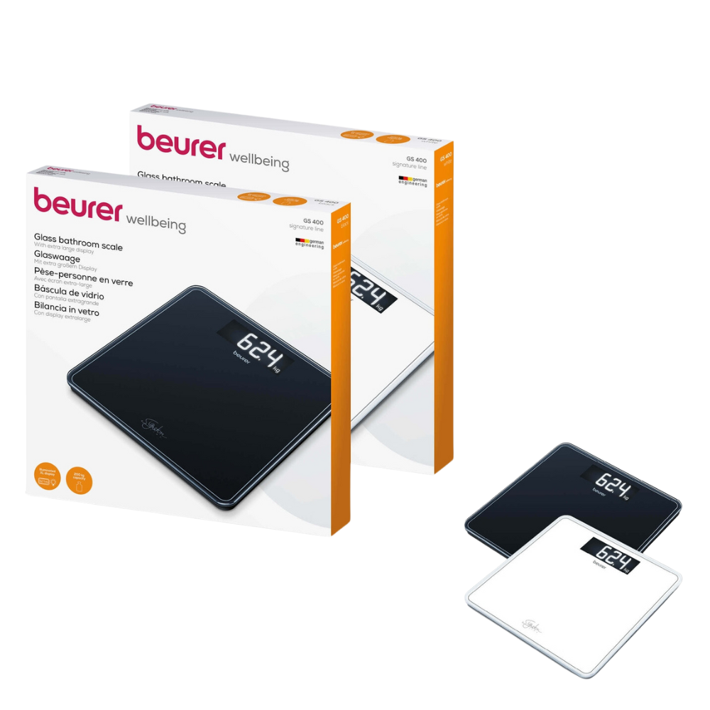 Two Beurer GS 400 body scales SignatureLine glass personal scales, one in black and one in white, are shown next to their respective packaging boxes. The packaging contains the trademark and product information of Beurer GmbH. The black scale shows "62.4" on its digital display.