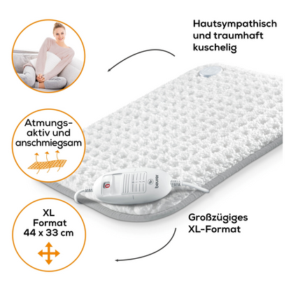 The Beurer HK 42 Heating Pad Super-Cosy from the Beurer GmbH is a white heating pad with a textured surface and the inscription "Skin-friendly and wonderfully cozy," "Breathable and cuddly" (breathable and cuddly), and in the generous XL format of 44 x 33 cm.