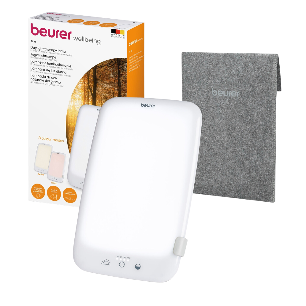 The Beurer daylight lamp TL 35 is depicted with its packaging and a gray felt cover. The packaging shows the image of the lamp and emphasizes its ability to offer 3 color modes. This rectangular lamp features a stand, control buttons like a dimmer, and bears the logo of Beurer GmbH both on the lamp and on the packaging.