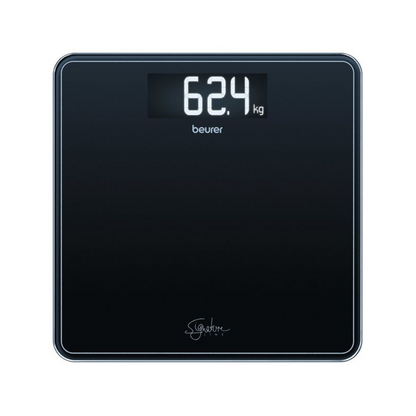 A Beurer GS 400 body scale SignatureLine shows a weight of 62.4 kilograms on its black surface, with a large, clear digital display at the top. Below the display, the brand "Beurer GmbH" is visible, next to the glass scale SignatureLine logo, which is attached to this 200 kg load capacity scale.