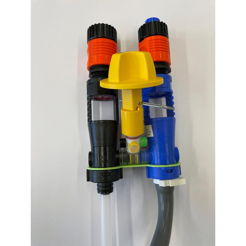Two dosing injectors, one black and one blue with an orange tip, are connected by a green band and a yellow cap with a lower gray hose. Part of the QuattroSelect Manifold Air Gap Oxivir Excel JFill Systems from Diversey Deutschland GmbH & Co. OHG.