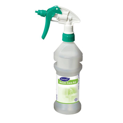 A clear Room Care R2 Plus Pur-Eco spray bottle, empty, from Diversey Deutschland GmbH & Co. OHG with a green and white trigger nozzle stands upright on a plain white background.