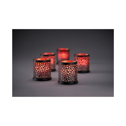 Eight glowing Multicolour LED Set, Mini candles from Duni GmbH in patterned holders cast a warm, colorful light through perforated patterns on a dark surface; the gently blurred background enhances the cozy atmosphere.