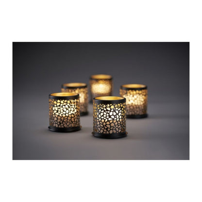 Eight colorful Duni GmbH Multicolour LED Mini candles shine through grid-shaped candle holders and cast magical shadows on a simple surface for creative lighting in a dim ambiance.
