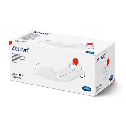 A box of Hartmann Zetuvit® absorbent compresses, predominantly white with red and blue design elements. The box shows the product name and dimensions (20 cm x 40) from Paul Hartmann AG.