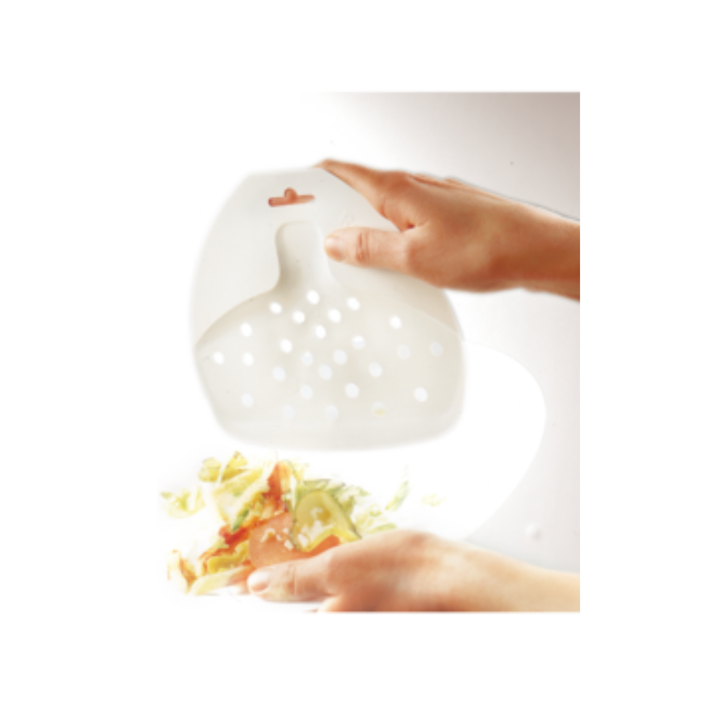 Hands hold a Haug plate scraper PP 160 x 180 mm, a translucent, perforated scraper made of polypropylene from Haug Bürsten KG, over a bowl with vegetable scraps, in accordance with HACCP guidelines.