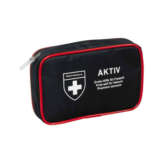A compact black first-aid kit with red trim and a zipper, featuring a white cross logo and the text “Holthaus Medical AKTIV” and “Erste-Hilfe für Freizeit / First-aid for Leisure / Premiers secours” on the front. Perfect for on the go and at home.
