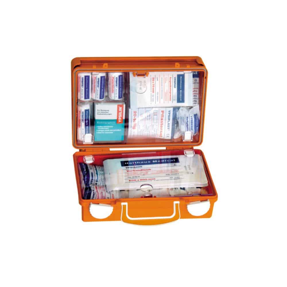 An open Holthaus Medical first aid kit QUICK, manufactured by Holthaus Medical GmbH & Co. KG, contains various medical supplies, including bandages, adhesive plasters, antiseptic wipes, and medical swabs. The items are neatly arranged in compartments in the case made of durable ABS plastic, produced according to DIN 13157.