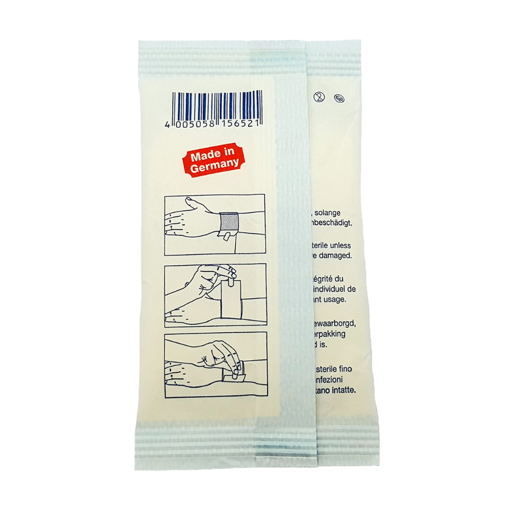 The image shows the back of a light beige packaging for a Holthaus Ypselast® quick bandage, manufactured by Holthaus Medical GmbH & Co. KG, with the label "Made in Germany". At the top, there is a barcode and three instructional images showing how to open the packaging by pulling it apart. The text instructions are available in multiple languages.