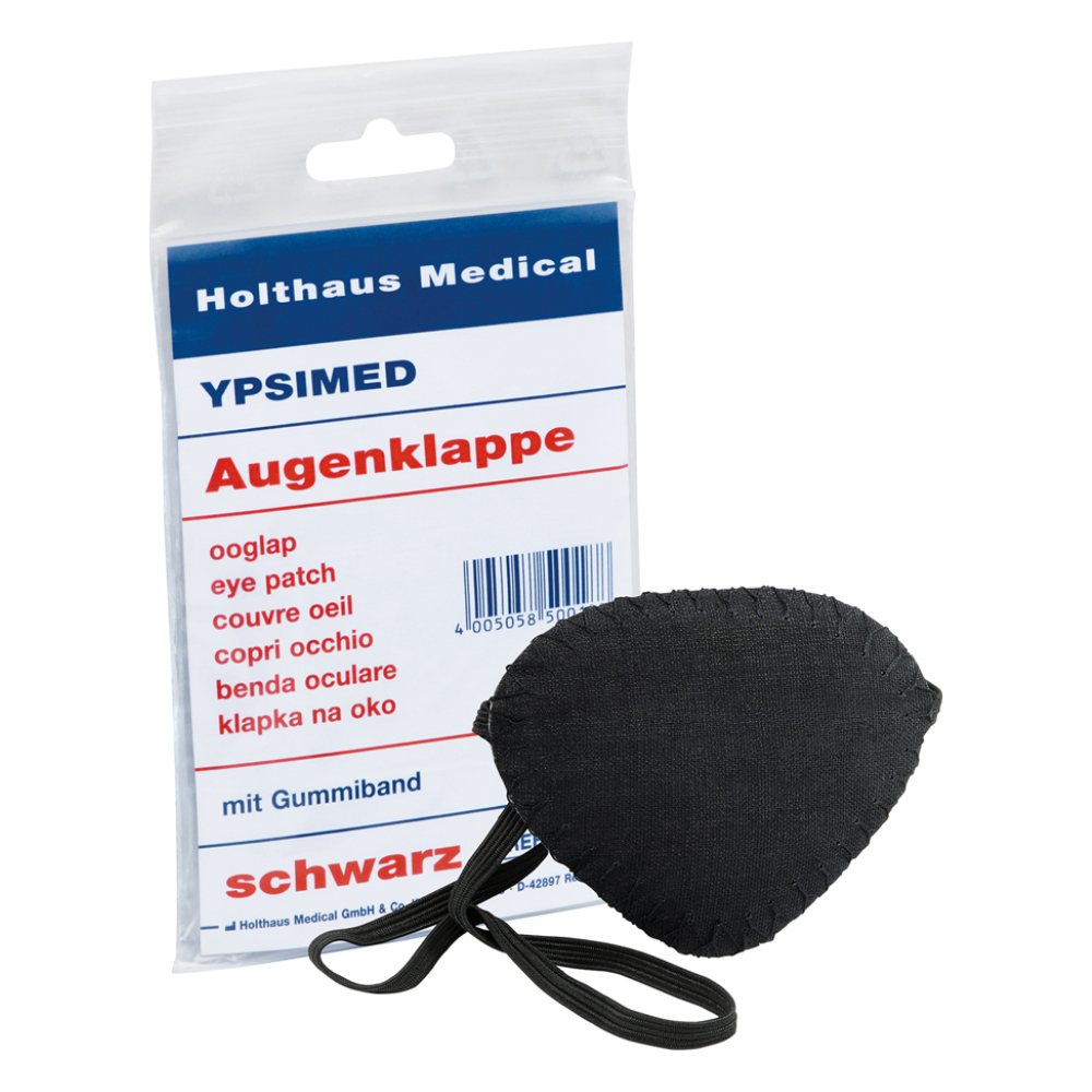Displayed is a Holthaus Ypsimed eye patch, with an elastic band, made of black fabric. Next to it is a plastic packaging with the inscription "Holthaus Medical GmbH & Co. KG", "YPSIMED" and "eye patch" in several languages, indicating its use as a medical aid for eye protection.