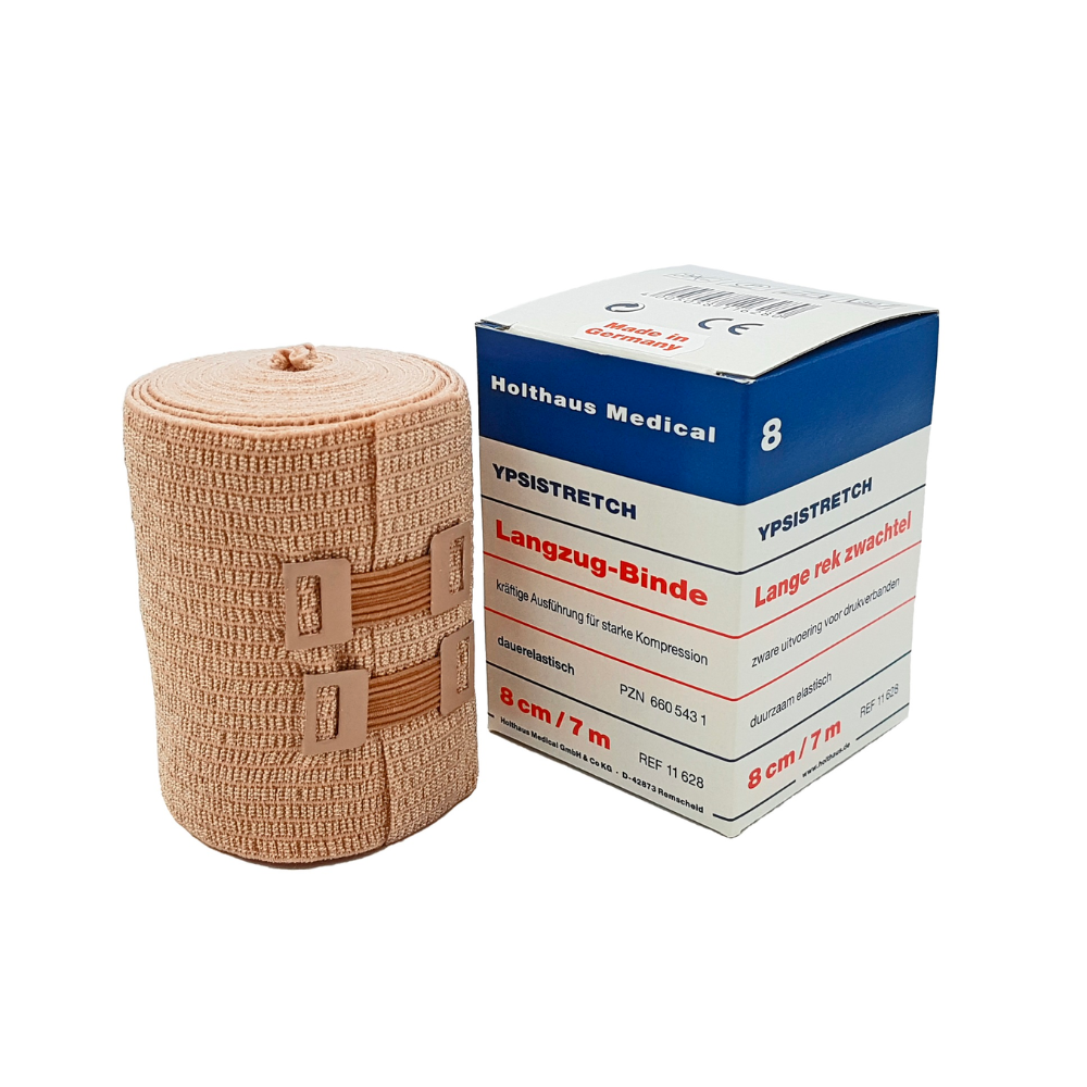 Next to the packaging, a medical elastic bandage is pictured. The box says "Holthaus Ypsistretch Long-stretch Bandage, strong" and the information is in German. The skin-colored bandage from Holthaus Medical GmbH & Co. KG provides effective compression and is fastened with two plastic closures.