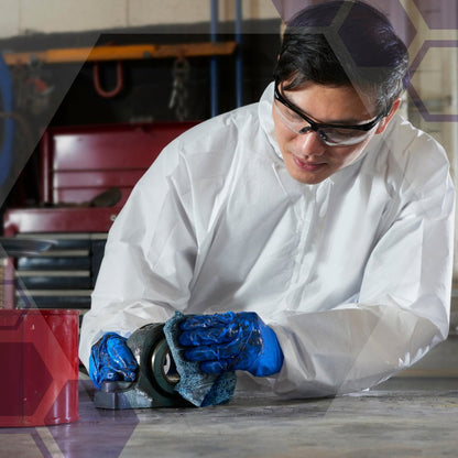 A person wearing safety glasses, a white suit, and blue gloves kneels on a concrete floor in an industrial cleaning environment and uses Kimberly-Clark GmbH's Kimtech® process wipes - BRAG™ Box to clean a metal object with a wipe.