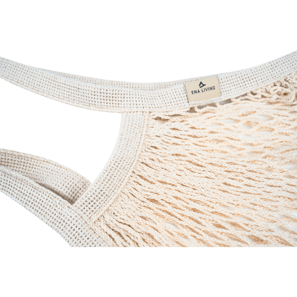 Close-up of the beige ENA Living shopping net from Abena Re-Seller GmbH with thick, braided handles and a small "ENA LIVING" tag. Ideal for environmentally conscious shopping. Packaging unit: box (24 packs), background: white.