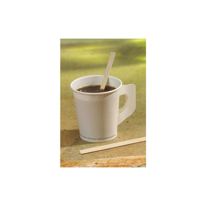 A white disposable cup with dark coffee holds a PAPSTAR wooden stirring stick "pure" 14 cm, environmentally friendly and stable from PAPSTAR GmbH, with another on the surface. Sunlight highlights these sustainable stirring sticks from the 1000-piece folding box.