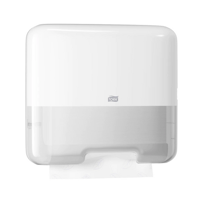 The Tork 553100 Mini Dispenser for Zigzag Hand Towels, designed in the modern Elevation H3 style, elegantly presents the brand "Tork" on the front. A transparent area at the bottom allows a view of a partially dispensed zigzag hand towel.