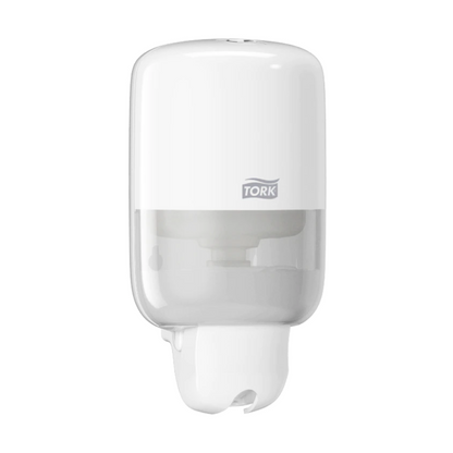 The Tork 561000 Mini Dispenser for Liquid Soap Elevation S2 from TORK - Essity Professional Hygiene Germany GmbH is a modern, white wall-mounted soap dispenser. It features a sleek design with a transparent lower part to display the liquid soap level, and the brand logo adorns the upper half.